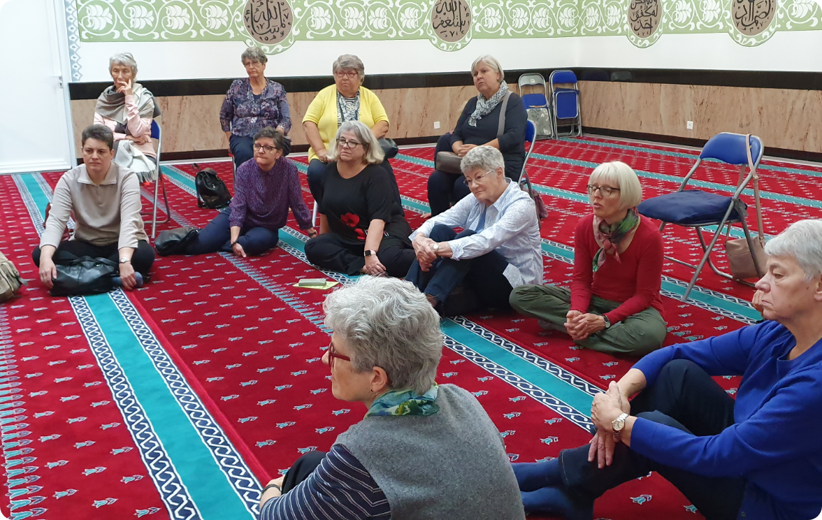 Eine Frauengruppe sitzt auf dem Boden einer Moschee